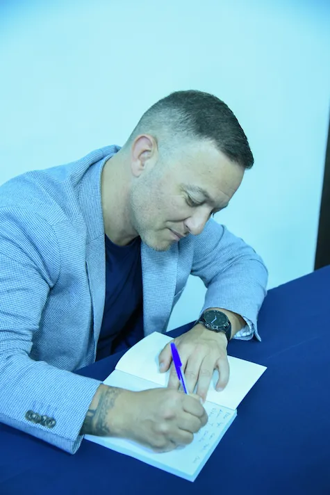 Ariel Díaz firmando ejemplares de Renacer con Propósito