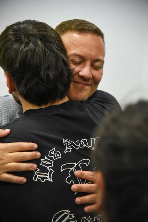 Abrazo cercano entre Ariel y un participante al cierre del evento