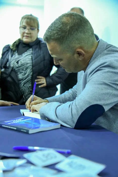 Ariel firmando ejemplares de Renacer con Propósito